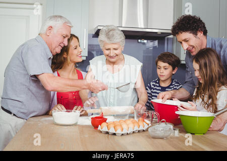 Smiling family preparing food in kitchen Banque D'Images
