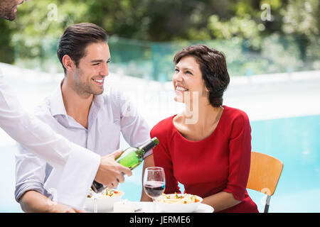 Waiter serving couple de vin rouge Banque D'Images