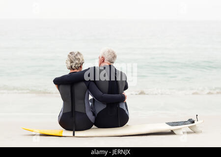 Vue arrière du couple sitting on surfboard Banque D'Images