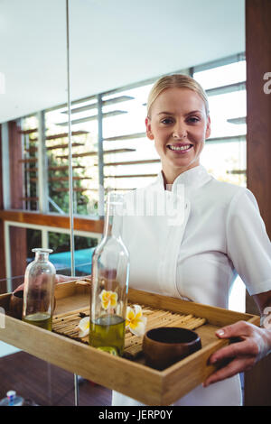 Smiling masseuse holding a tray Banque D'Images