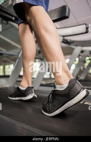 Les pieds de l'homme en marchant sur thread mill Banque D'Images