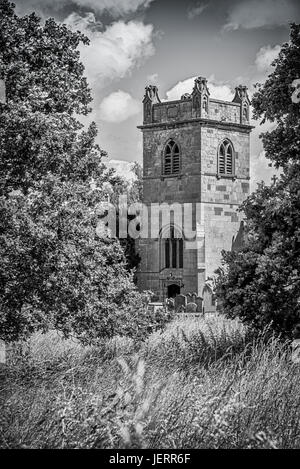 Un mono noir et blanc image en format vertical vertical d'un village de campagne anglaise tour de l'église entourée d'arbres Banque D'Images