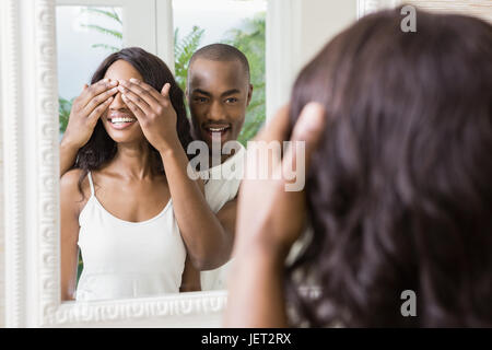 Jeune homme couvrant les yeux de womans Banque D'Images