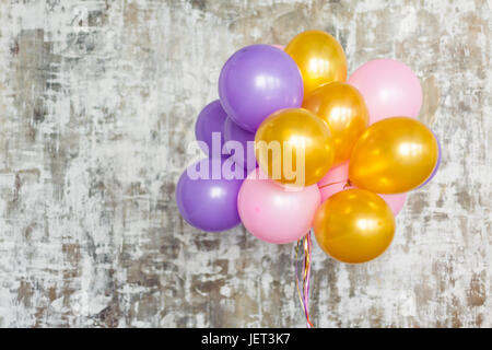 Bouquet de ballons lumineux contre un mur texturé. Copy space Banque D'Images