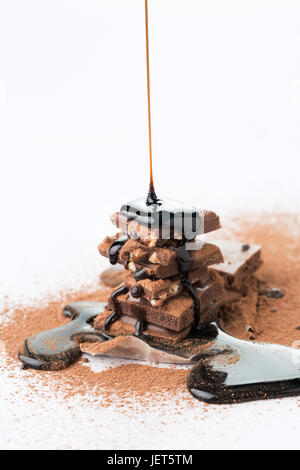 Le chocolat avec du cacao en poudre, sirop saupoudrées de vide sur fond blanc Banque D'Images