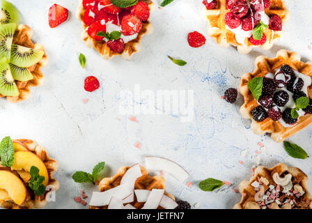 Ensemble de plaquettes soft belges avec différents toppings - pêche, mûres, framboises, fraises, noix de coco, noix de cajou, les fraises, la menthe. La lumière Banque D'Images