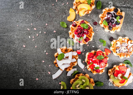 Ensemble de plaquettes soft belges avec différents toppings - pêche, mûres, framboises, fraises, noix de coco, noix de cajou, les fraises, la menthe. Black Banque D'Images