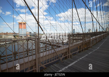 En regardant vers le pont de Manhattan à travers les fils sur le pont de Brooklyn New York USA Banque D'Images