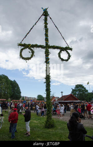 Stockholm, Suède - le 23 juin 2017. Les gens célébrant le milieu de l'appartement de suédois en relevant le maypole couverte de fleurs et de feuilles dans Scandic Infra City, un s Banque D'Images