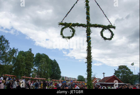 Stockholm, Suède - le 23 juin 2017. Les gens célébrant le milieu de l'appartement de suédois en relevant le maypole couverte de fleurs et de feuilles dans Scandic Infra City, un s Banque D'Images