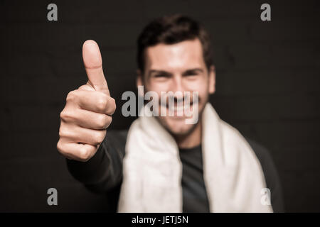 Close-up portrait of handsome man avec une serviette sur les épaules, showing thumb up Banque D'Images