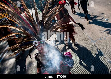 Une femme mexicaine, portant une large coiffe de plumes, exécute un Cœur mort danse culte dans la rue pendant le Jour des Morts procession dans la ville de Mexico, Mexique, 29 novembre 2016. Le Jour des Morts (Dia de muertos), une fête religieuse syncrétique c | conditions dans le monde entier Banque D'Images