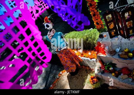 Drapeaux en papier ciselé (papel picado) sont accrochés sur l'autel des morts (Autel de muertos), un site religieux en l'honneur du défunt, au cours de la journée de célébration des morts à Morelia, Michoacan, Mexique, 3 novembre 2014. Le Jour des Morts ('ÄòDia dans le monde d'utilisation de Muerto | Banque D'Images