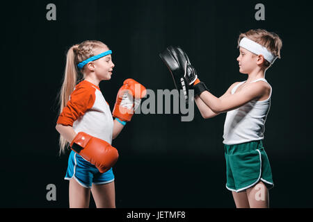 Vue latérale d'enfants semblant isolé sur la boxe, noir concept active kids Banque D'Images