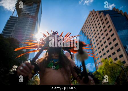 Un homme, portant un couvre-chef en plumes colorés inspirés par les Aztèques, tambour joue pendant le Jour des morts célébrations dans la ville de Mexico, Mexique, 29 novembre 2016. Le Jour des Morts (Dia de muertos), une fête religieuse syncrétique combinant la mort venerati | conditions dans le monde entier Banque D'Images