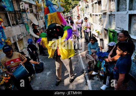 Un homme portant un costume de Bull, accompagnés par des musiciens, effectue pendant le Jour des morts dans le cimetière de Morelia, Michoacan, Mexique, 2 novembre 2014. Le Jour des Morts ('ÄòDia de muertos'Äô) est une fête religieuse syncrétique, celebra | conditions dans le monde entier Banque D'Images