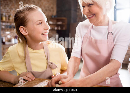 Grand-mère et enfant dans la cuisine équipée et le pétrissage de la pâte à biscuits, concept de cuisine de grand-mère Banque D'Images