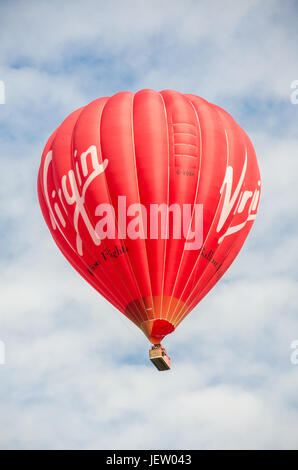 Une Vierge hot air balloon vole bas. Banque D'Images