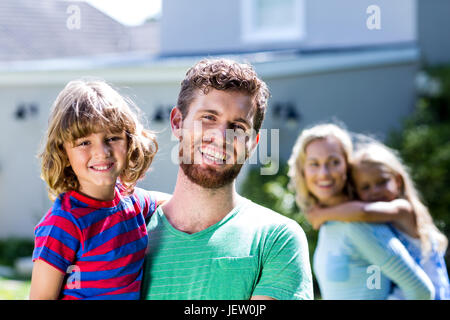 Happy Family standing against house Banque D'Images