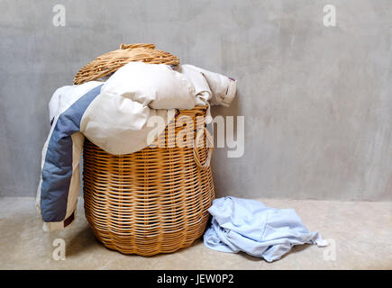 Panier à linge en osier débordante. Tâche ménagère concept. Banque D'Images