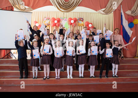 ST. PETERSBURG, RUSSIE - circa 2017 MAI : l'enseignant et ses étudiants brandissent des certificats à l'école en l'honneur de la fin de la deuxième année Banque D'Images