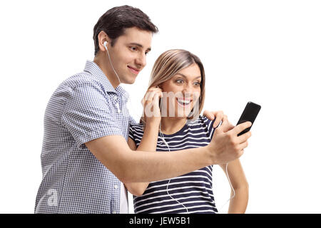 Jeune couple d'écouter de la musique sur un téléphone portable isolé sur fond blanc Banque D'Images