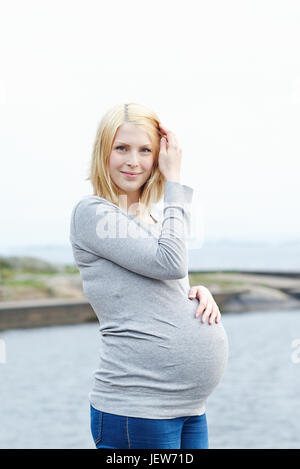 Femme enceinte avec les mains sur le ventre de l'enfer Banque D'Images