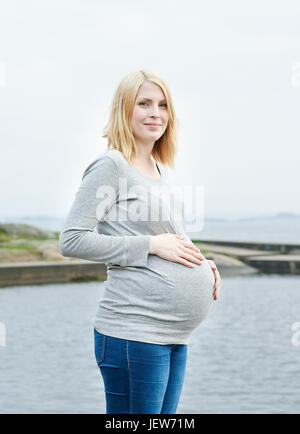 Femme enceinte avec les mains sur le ventre de l'enfer Banque D'Images