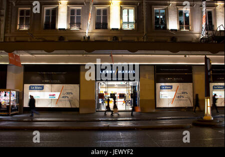 Voir des gens marcher dans motion floue en face d'un célèbre magasin de nuit dans le quartier du Marais de Paris. Le consumérisme et la période des ventes de con Banque D'Images