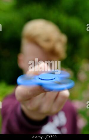 Osterode, Allemagne. 27 Juin, 2017. Un garçon joue avec la en ce moment, soi-disant populaires jouet anti-stress connu comme un 'fidget spinner", l'Allemagne, ville d'Osterode, 27. Juin 2017. Photo : Frank May (modèle) parution dans le monde d'utilisation |/dpa/Alamy Live News Banque D'Images