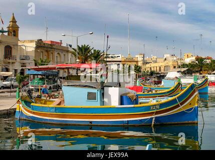 Marsaxlokk, Malte. 27 Sep, 2004. Ancré dans la baie de Marsaxlokk, bateaux de pêche aux couleurs vives sont appelés luzzus. Ils sont traditionnels dans ce village de pêcheurs pittoresque dans la région sud-est de l'île de Malte qui est devenue une destination touristique internationale. Les touristes visitent la ville pour le pittoresque des photos. Credit : Arnold Drapkin/ZUMA/Alamy Fil Live News Banque D'Images