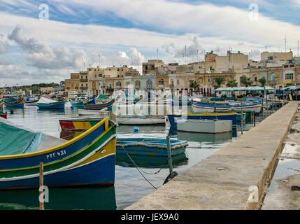 Marsaxlokk, Malte. 27 Sep, 2004. Ancré dans la baie de Marsaxlokk, bateaux de pêche aux couleurs vives sont appelés luzzus. Ils sont traditionnels dans ce village de pêcheurs pittoresque dans la région sud-est de l'île de Malte qui est devenue une destination touristique internationale. Les touristes visitent la ville pour le pittoresque des photos. Credit : Arnold Drapkin/ZUMA/Alamy Fil Live News Banque D'Images