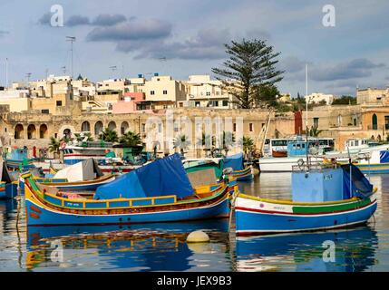 Marsaxlokk, Malte. 27 Sep, 2004. Ancré dans la baie de Marsaxlokk, bateaux de pêche aux couleurs vives sont appelés luzzus. Ils sont traditionnels dans ce village de pêcheurs pittoresque dans la région sud-est de l'île de Malte qui est devenue une destination touristique internationale. Les touristes visitent la ville pour le pittoresque des photos. Credit : Arnold Drapkin/ZUMA/Alamy Fil Live News Banque D'Images