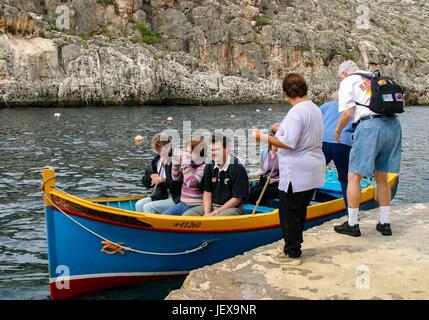 Le 27 septembre 2004 - Village Zurrieq, Malte - au départ du quai touristique traditionnel maltais colorés bateaux de pêche appelée luzzu pour visiter la grotte bleue, une formation de roches naturelles sauvages et cavernes de la mer au large de la côte sud de Malte, une populaire destination touristique internationale. (Crédit Image : © Arnold Drapkin via Zuma sur le fil) Banque D'Images