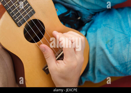 Détail de l'homme de vous détendre sur un hamac et jouer ukulele. Banque D'Images