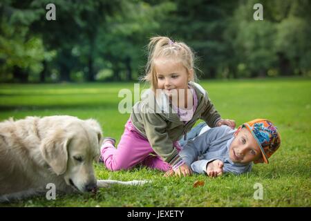 Frères et sœurs avec un golden retriever Banque D'Images