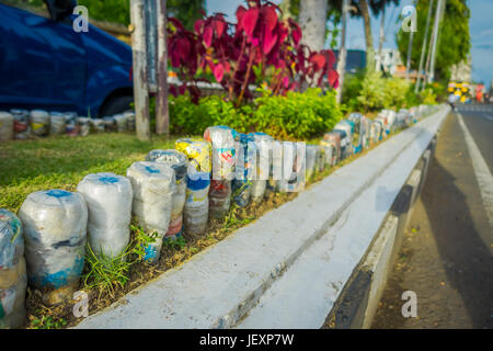 BALI, INDONÉSIE - Mars 08, 2017 : Une des bouteilles d'eau en plastique dans le parc à l'envers dans la rangée, recyclé pour orner les parcs et avenues, la notion d'envir Banque D'Images