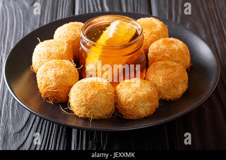 Kataifi dessert traditionnel du Moyen-Orient avec du miel sur une plaque horizontale. Banque D'Images