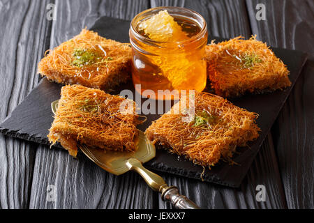 Sweet dessert oriental kunafeh de pistaches et de miel frais close-up sur la table horizontale. Banque D'Images