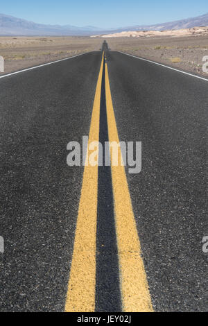 Longue route en ligne droite dans le désert de la Death Valley, Californie Banque D'Images