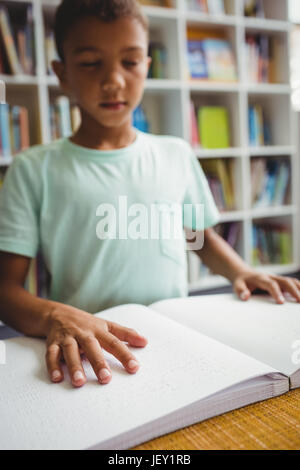 Garçon en utilisant le braille pour lire Banque D'Images