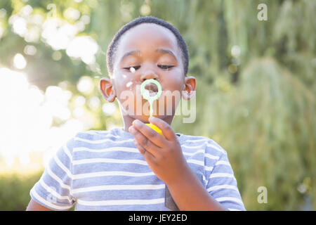 Boy making bubble avec bubble wand Banque D'Images