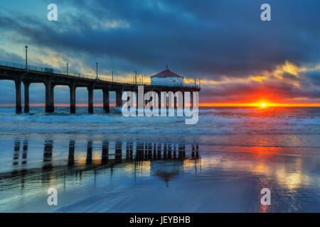 Coucher de soleil sur l'océan Pacifique à la Manhattan Beach Pier photographié à partir de la partie nord de la jetée de Manhattan Beach, CA. Banque D'Images