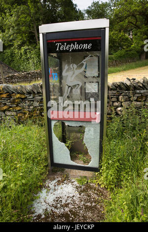 Torver, pont, vandalisé pays village phone box avec panneau de porte en verre brisé Banque D'Images