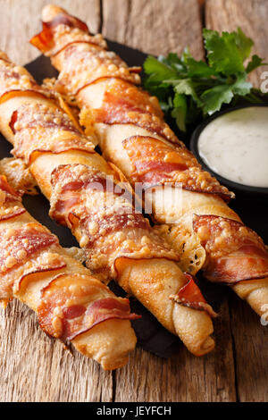 Pain Long stick avec bacon et fromage close-up et à la crème sur la table verticale. Banque D'Images