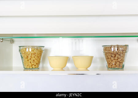 Les ingrédients alimentaires organisées sur une étagère sur comptoir cuisine moderne. Cuisine simple blanc. Banque D'Images