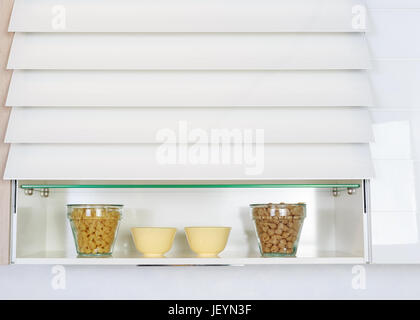 Les ingrédients alimentaires organisées sur une étagère sur comptoir cuisine moderne. Cuisine simple blanc. Banque D'Images