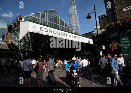 Borough Market rouvre au public après avoir été fermée à Londres, Angleterre, Royaume-Uni. Tout était revenu à la normale avec des personnes et des travailleurs autour de la zone du pont de Londres, sortir après le travail à la Porter du marché pub, qui a été fermé à la suite de l'attaque terroriste de London Bridge. Les amis traînent comme normal pour les boissons sur un soir d'été. Banque D'Images