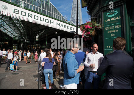 Borough Market rouvre au public après avoir été fermée à Londres, Angleterre, Royaume-Uni. Tout était revenu à la normale avec des personnes et des travailleurs autour de la zone du pont de Londres, sortir après le travail à la Porter du marché pub, qui a été fermé à la suite de l'attaque terroriste de London Bridge. Les amis traînent comme normal pour les boissons sur un soir d'été. Banque D'Images