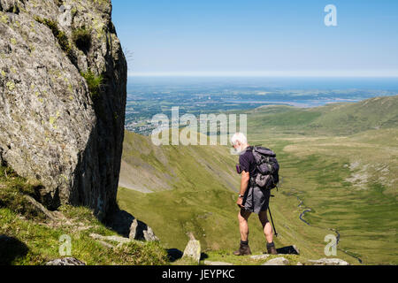 Grimpeur Senior scrambling sur Llech Ddu spur ou berceau Lem sur Carnedd Dafydd dans Carneddau montagnes de Snowdonia National Park avec l'autre au-delà.Wales UK Banque D'Images